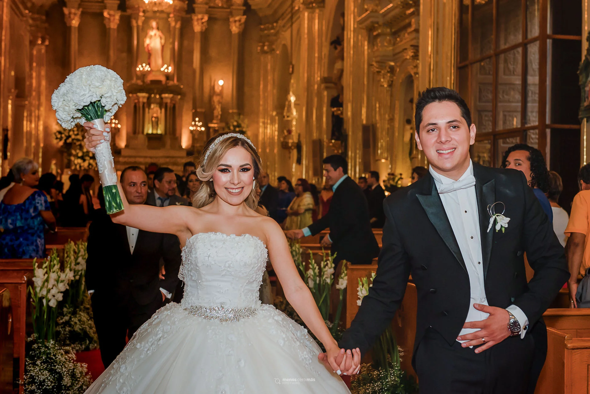 novia con brazo en alto al salir de la boda