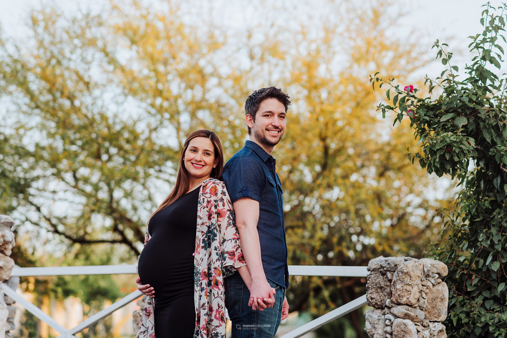 Susy y su esposo, unidos por el amor y la esperanza, se toman de la mano en un puente del Parque Cumbres Elite Sec. Hacienda durante su sesión prenatal.