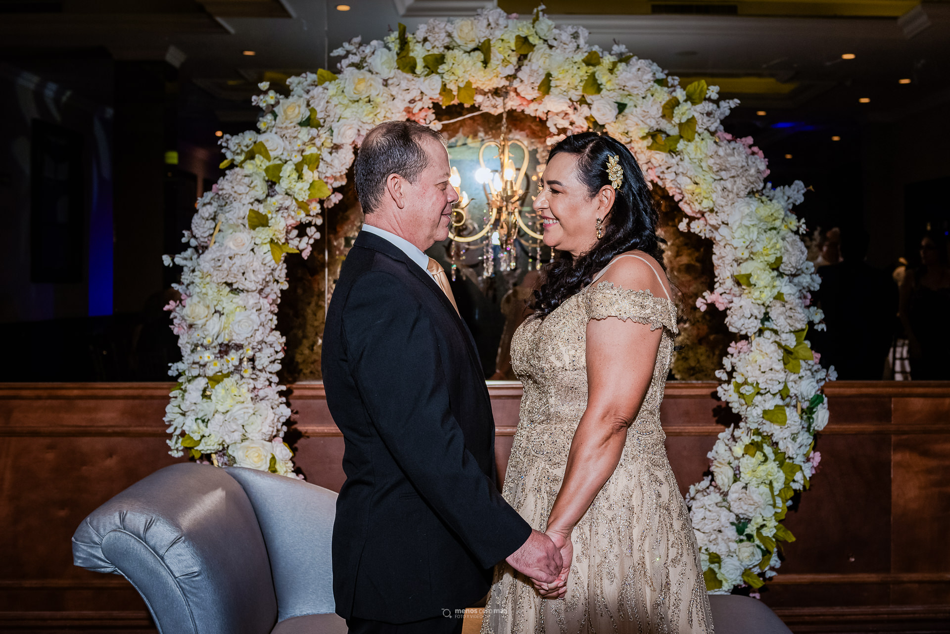 Fotografía de Juan y Lety sonriendo frente a decoración principal en su aniversario matrimonial en Monterrey