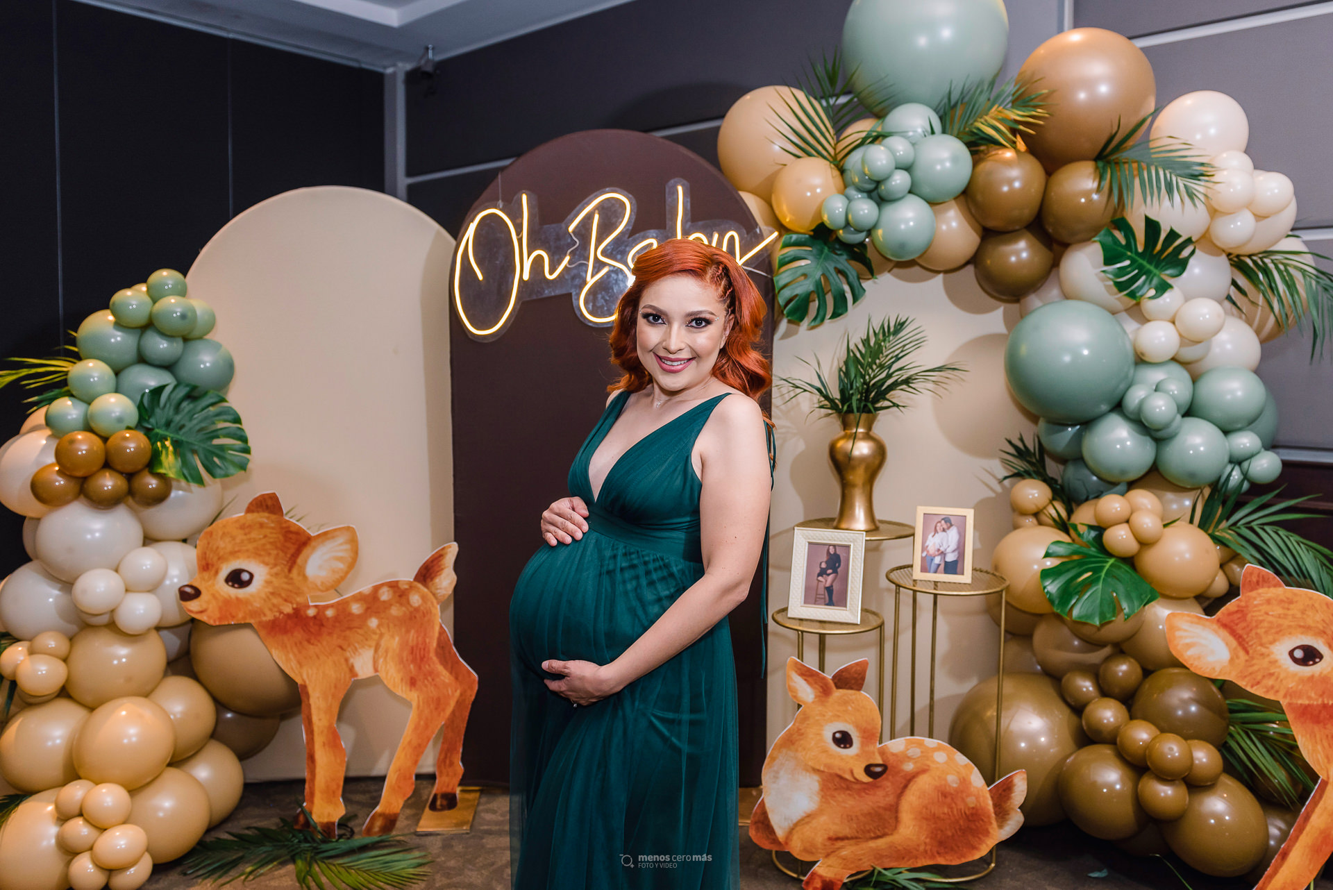 Fotografía de Tania en su babyshower en Windsor Eventos, con un vestido verde y una decoración de temática safari en tonos cafés y verdes, con globos y venados.
