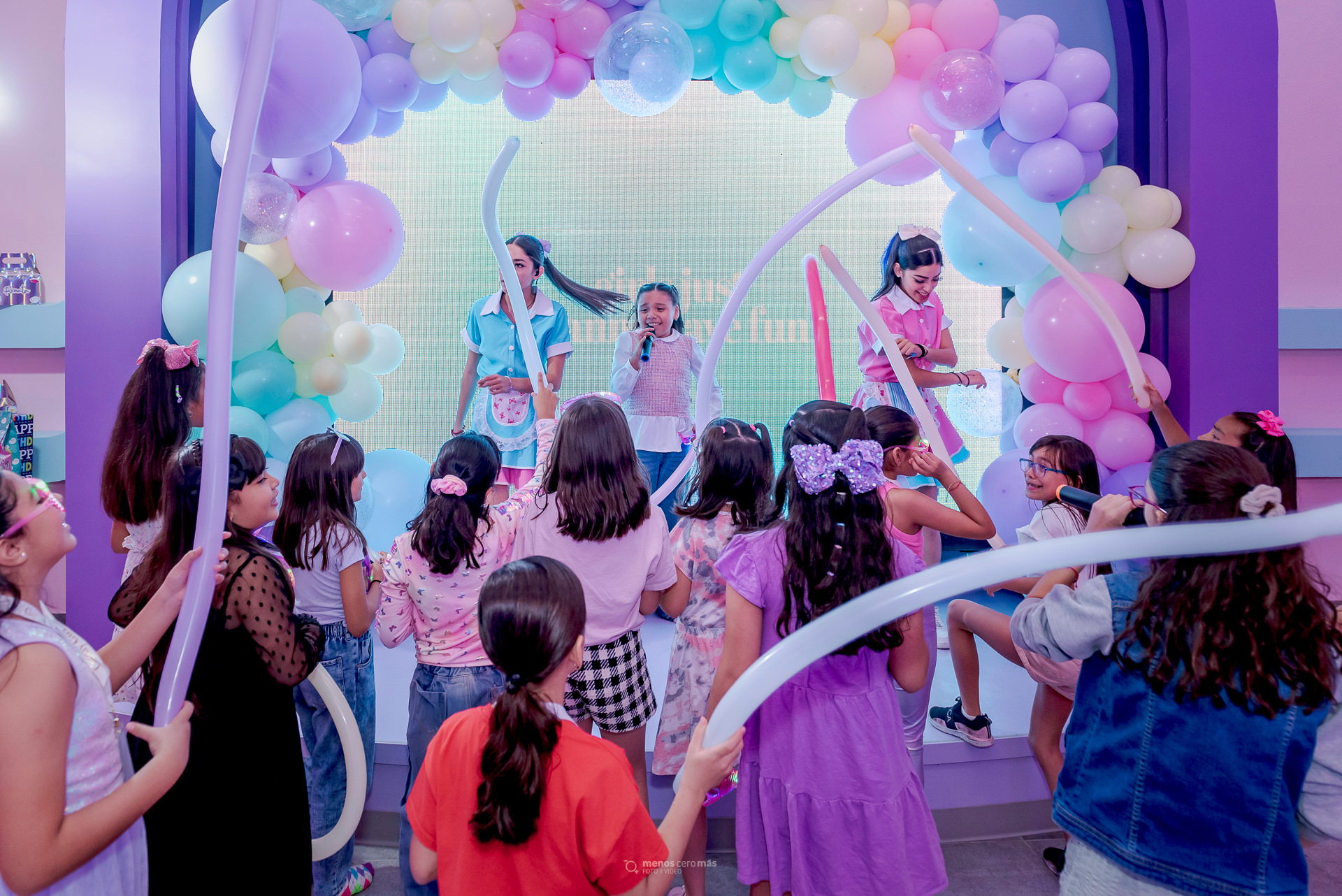 Fotografía de fiesta infantil: Renata celebrando su 9° cumpleaños en CandyBox Monterrey. La cumpleañera se encuentra en el escenario, sonriente y rodeada de sus amigas, quienes la acompañan en este día tan especial.