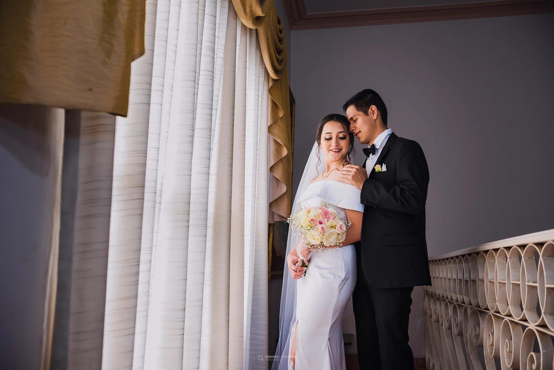 Imagen de Montserrat y Cesar en una sesión casual de fotos de boda en Estudio 949, posando frente a un ventanal de la casona del estudio.