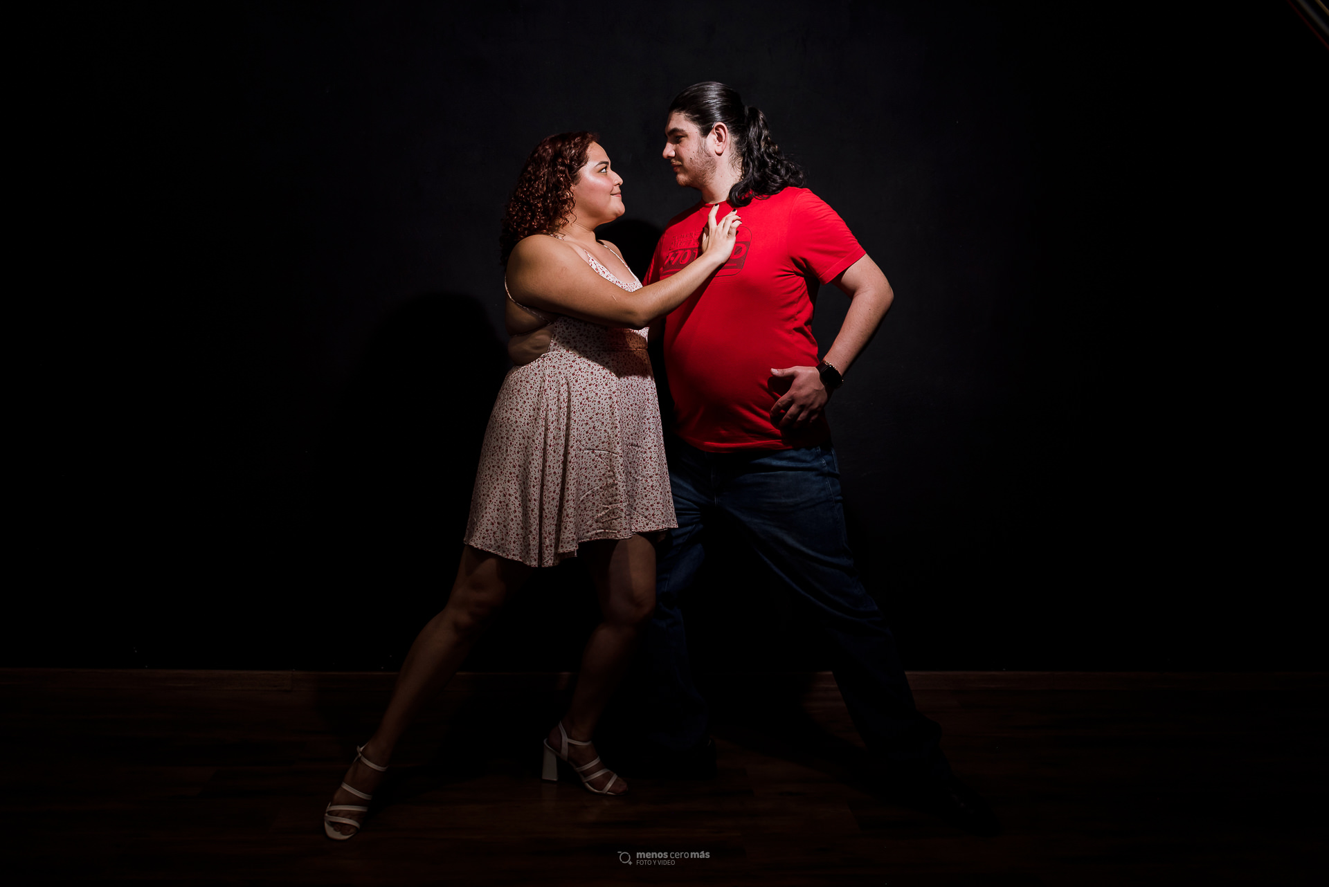 Fotografía de Laura y Gil realizando una pose de tango clásico en una sesión informal en la Escuela de Tango Monterrey, iluminados por una única luz en la oscuridad.