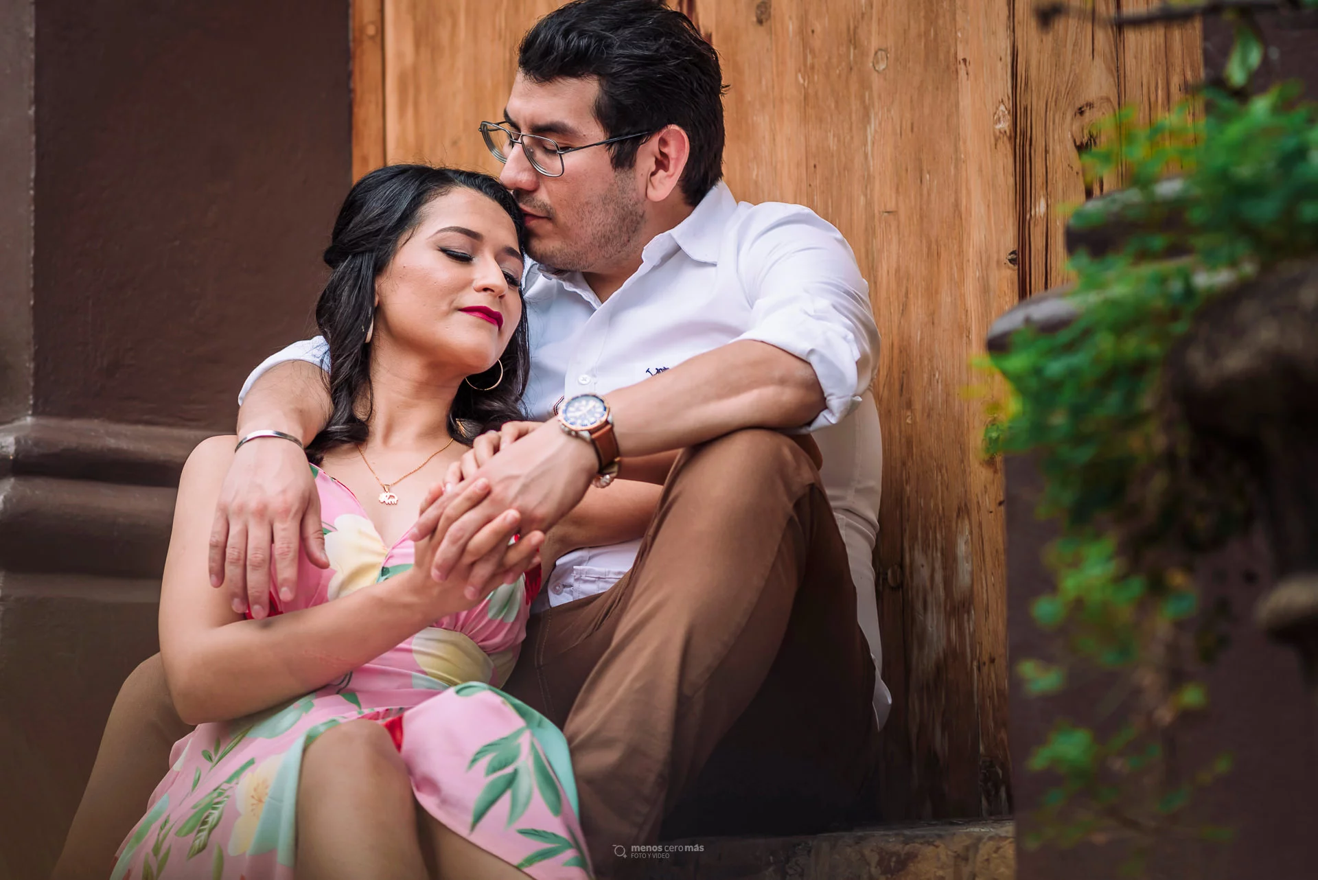 Nohemí y Alejandro comparten un momento de su sesión casual en una casona con arquitectura típica del municipio de Santiago, Nuevo León. La imagen los muestra sentados en los escalones de la entrada, con una sonrisa cómplice y disfrutando del atardecer.
